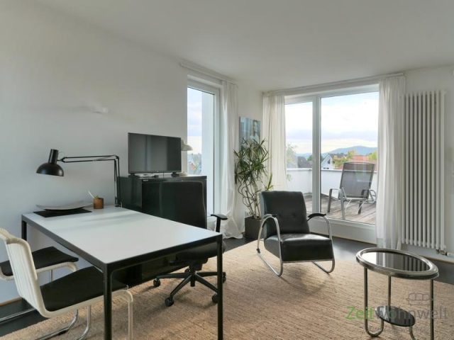 TV, Sessel und Terrassenfenster