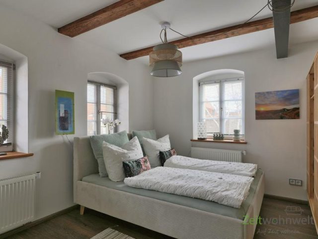 Doppelbett hinter dem Raumteiler