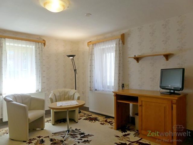 Wohnzimmer, TV, Schreibtisch und Sessel