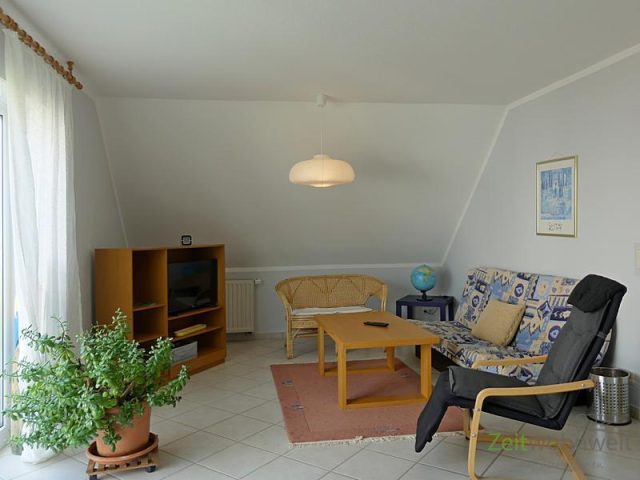 Couch und TV im rechten Wohnzimmerbereich