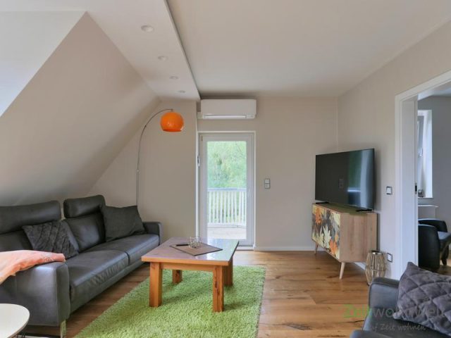 Sofa und TV vor dem Balkonausgang